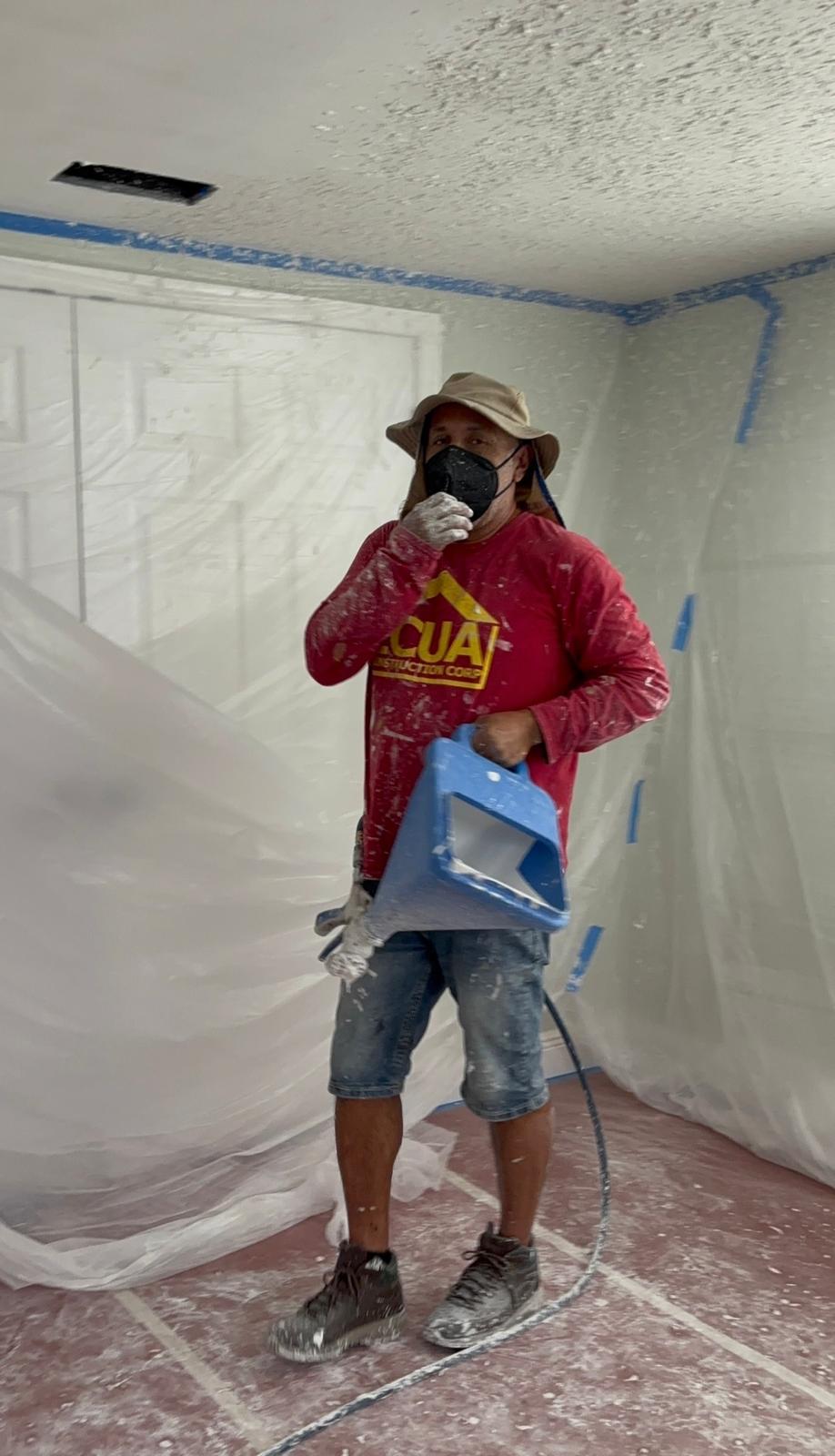 Ecuaconstruction craftsman applying knockdown drywall ceiling texture with full room containment