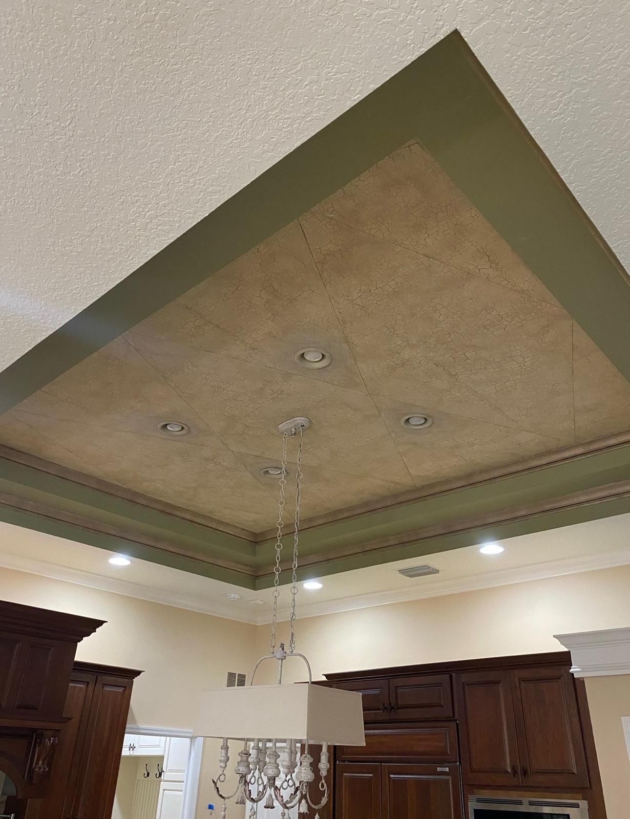 Artisan tray ceiling with geometric faux texture finish, multi-layer olive green crown moulding, and recessed lighting over custom kitchen in Odessa FL
