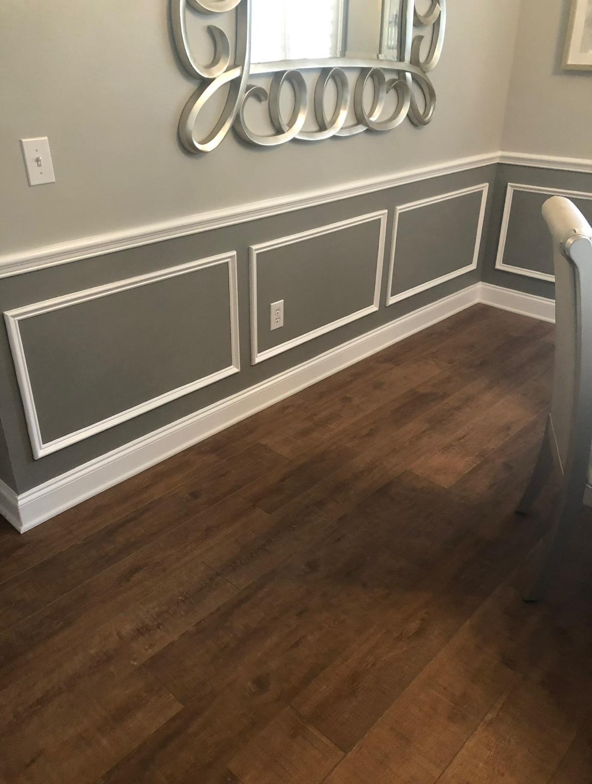 Dining room interior two-tone painting featuring charcoal grey chair rail wainscoting and crisp semi-gloss white shadowbox trim in Wesley Chapel FL