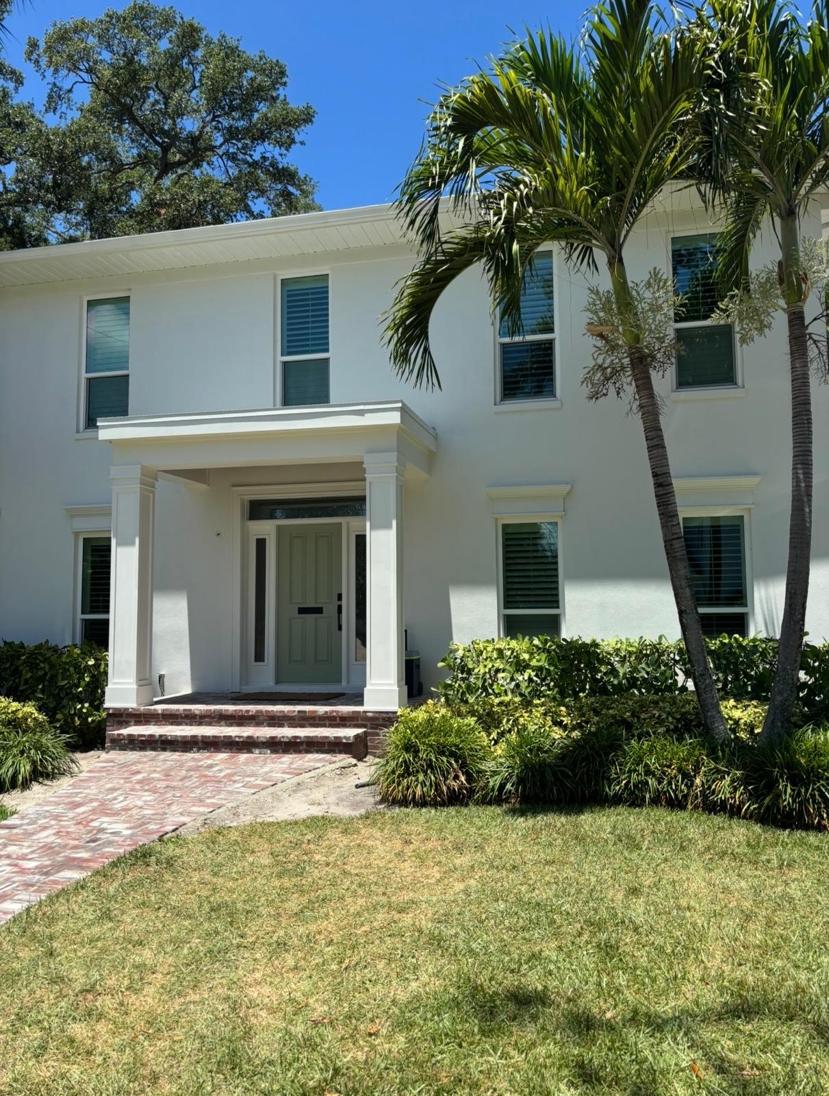 Two-story luxury home exterior painting with custom front door and trim in Land O' Lakes FL