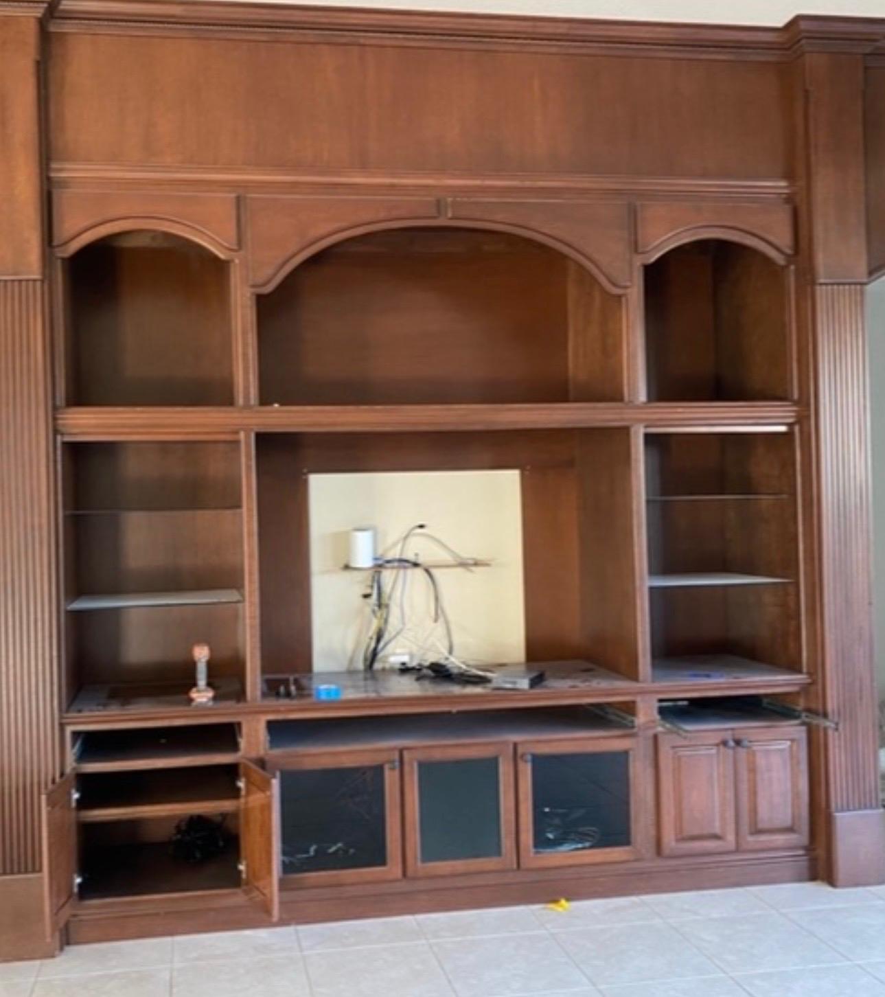 Built-in living room media center cabinetry before spray painting and refinishing by Ecuaconstruction Corp
