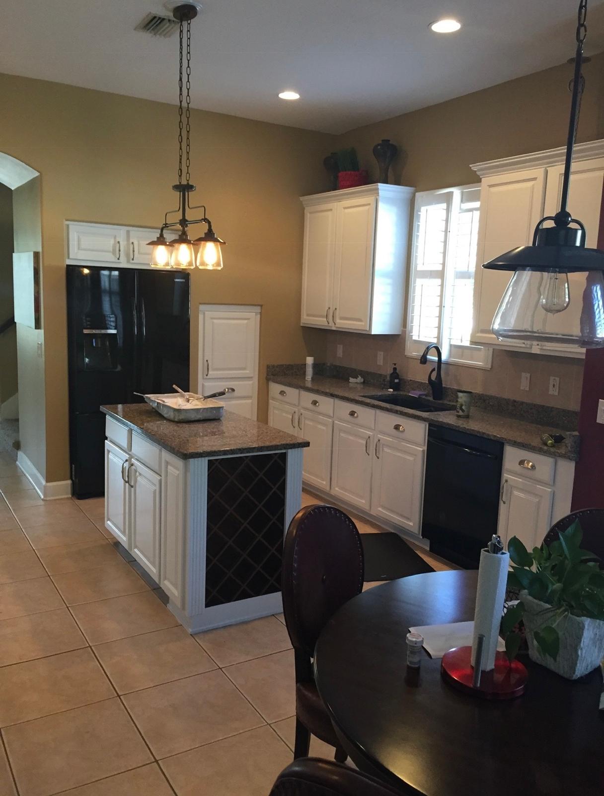 White painted kitchen cabinets with custom wine rack island and warm interior wall painting in Odessa FL