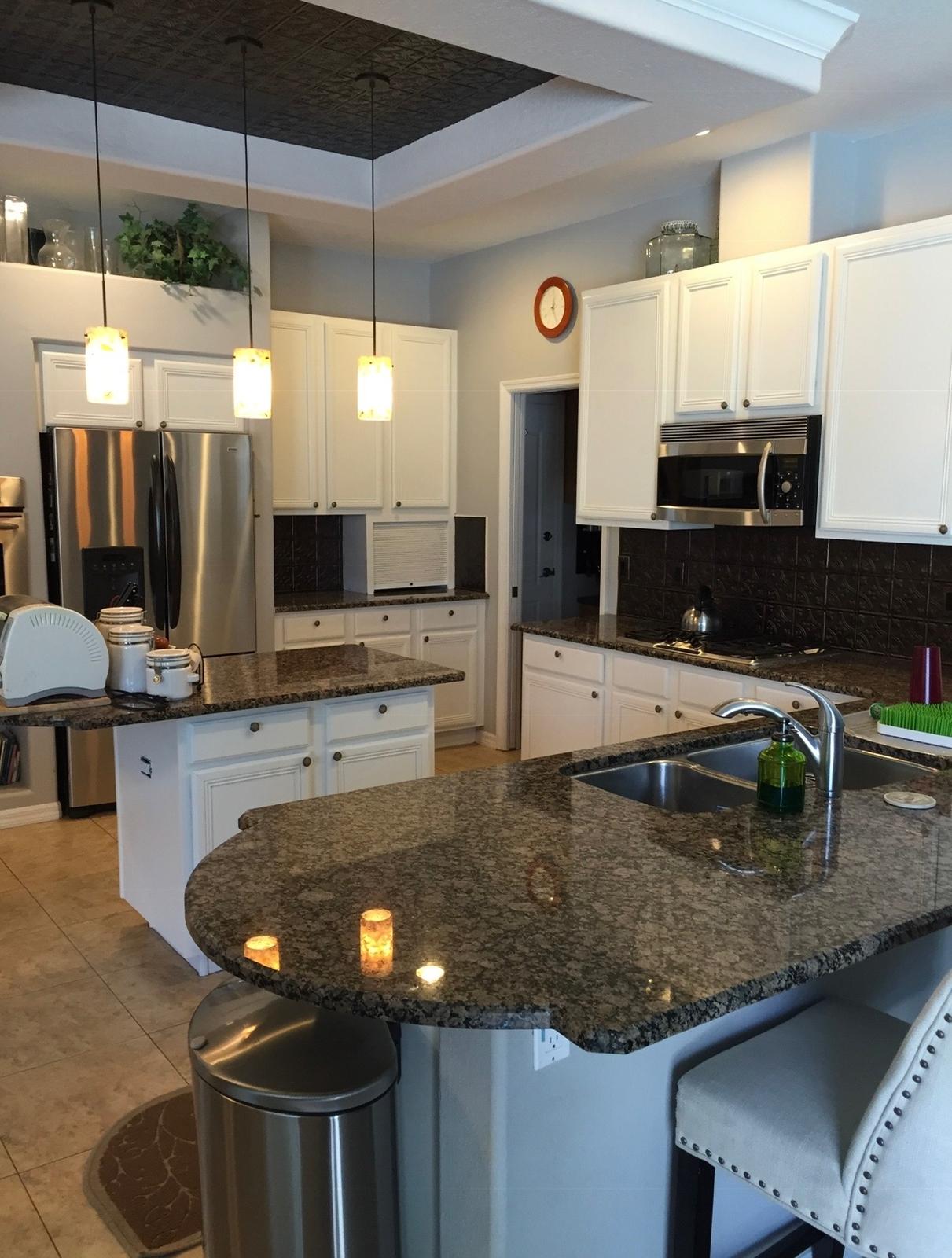 Kitchen cabinet spray refinishing in factory white with granite countertops and recessed stamped ceiling in Wesley Chapel FL