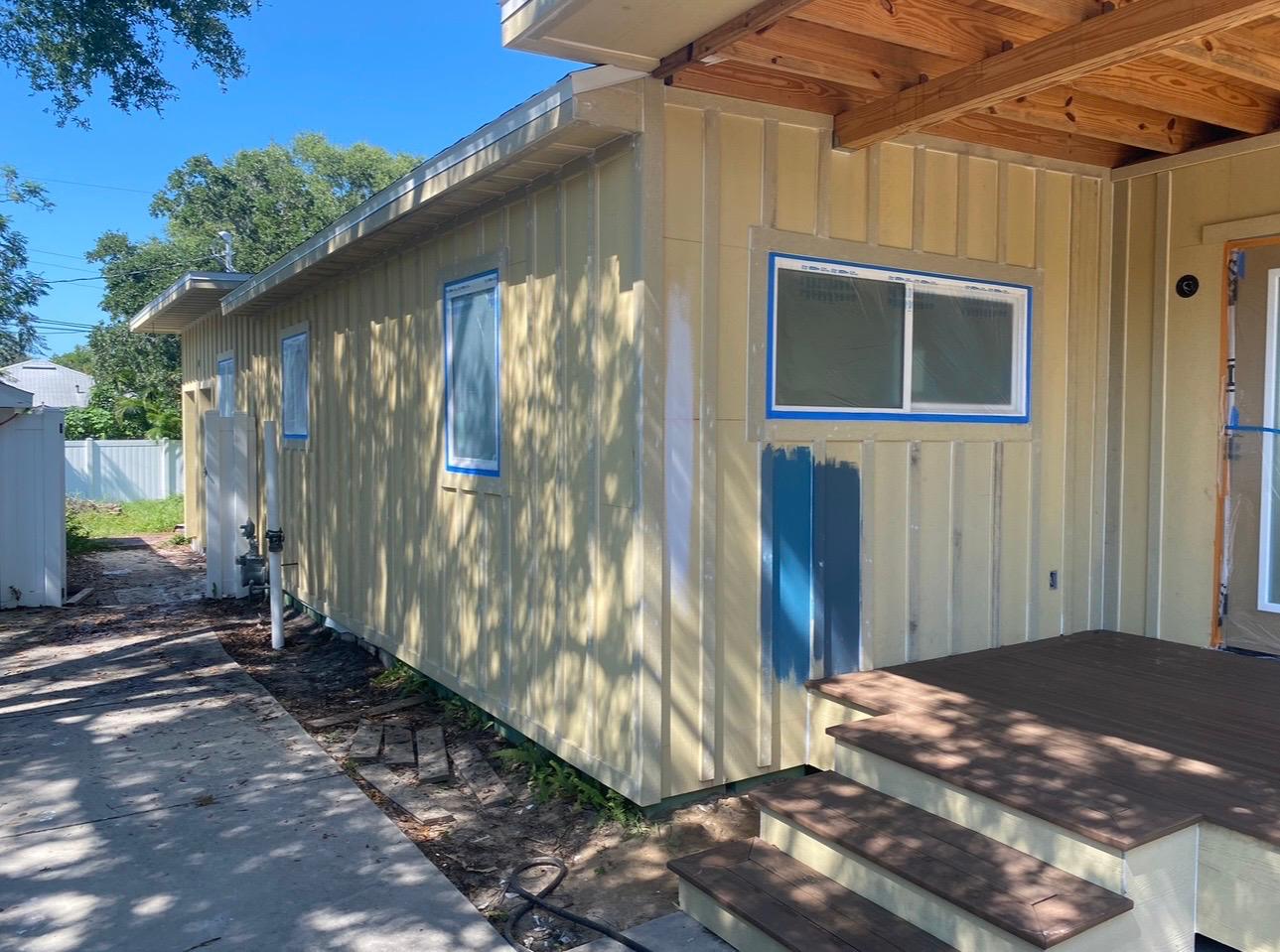 Board and batten home exterior painting prep, window masking, and test color swatch evaluation in Wesley Chapel FL