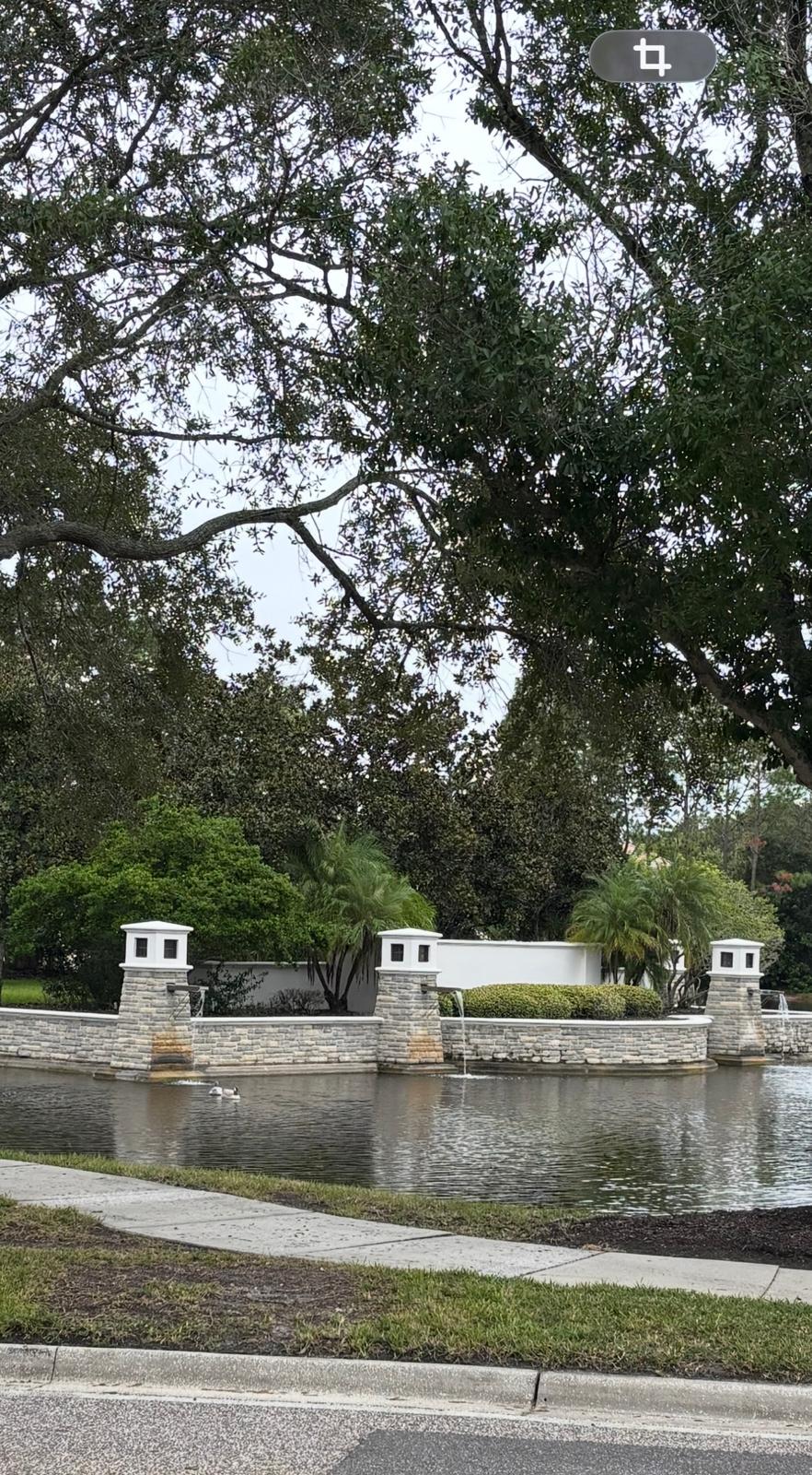 Stone perimeter wall and fountain restoration across lakefront entrance in Tampa Bay FL