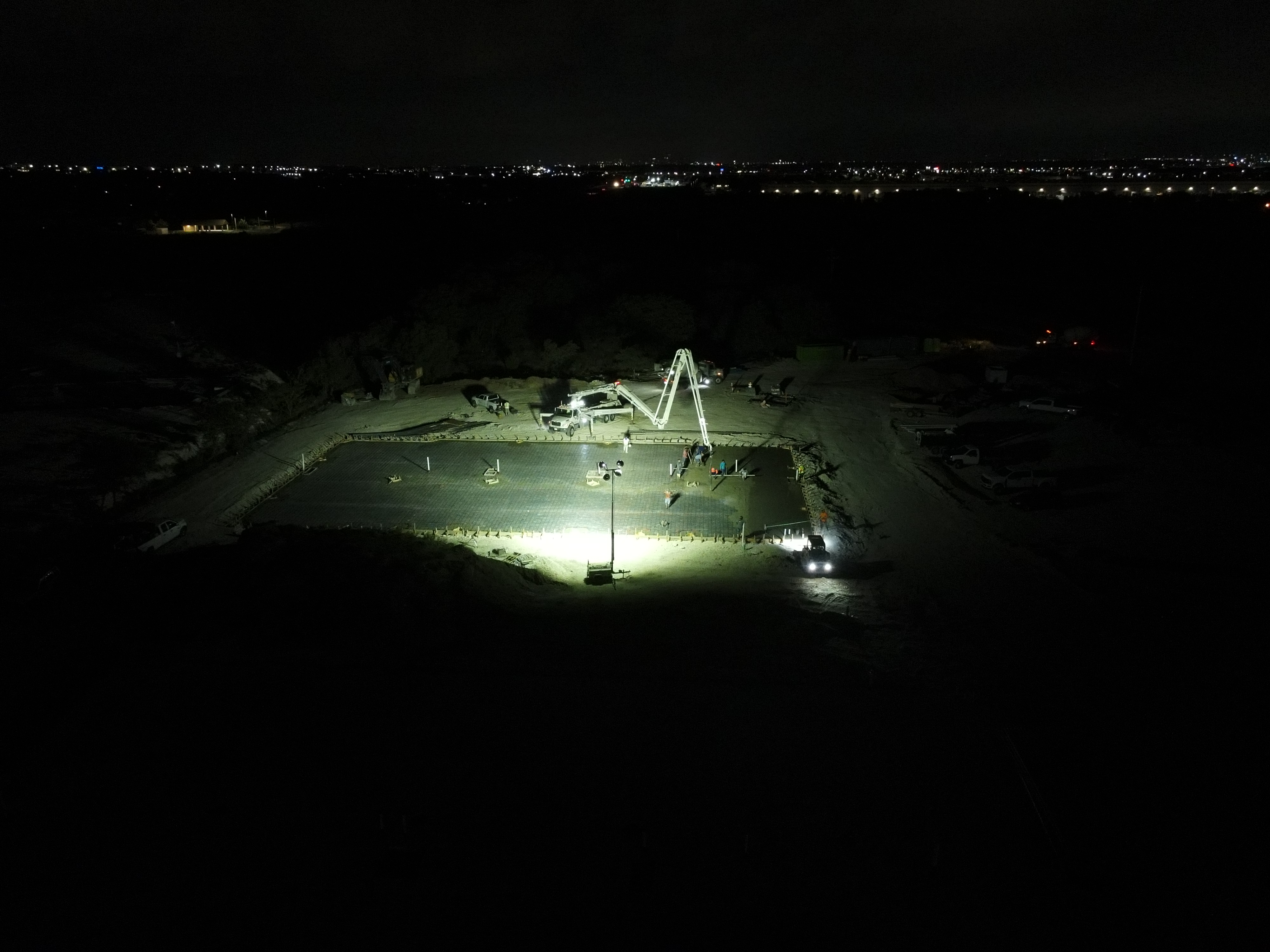High volume night commercial concrete pour with boom pump truck on reinforced warehouse slab by JIC Concrete in Texas