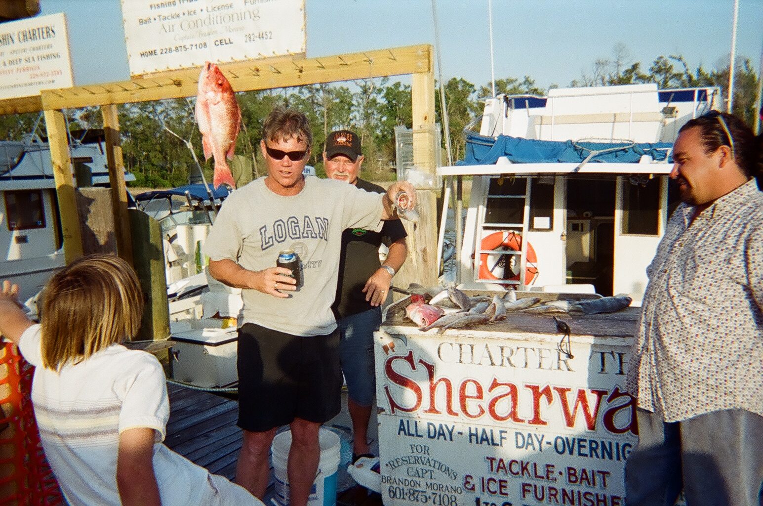 Vintage photo of the original Shearwater Charters sign with red snapper and speckled trout at the dock