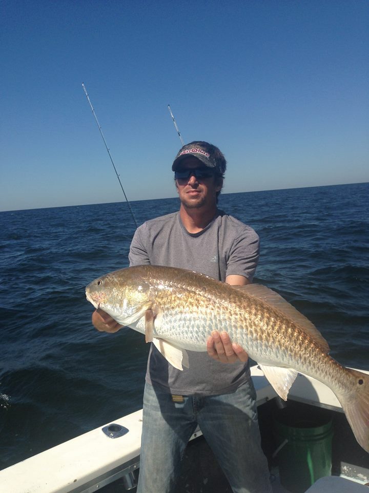 Angler holding a large bull redfish caught on a half-day fishing trip near Biloxi, MS