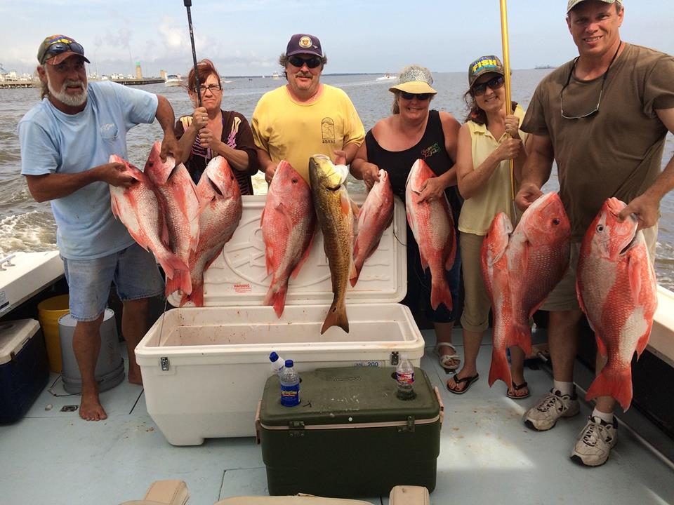 Group of six anglers holding red snapper on the deck of a Biloxi red snapper fishing charter