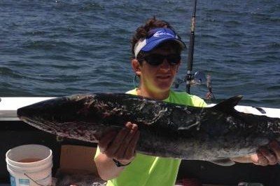 Angler holding a king mackerel caught on a trolling trip near Biloxi