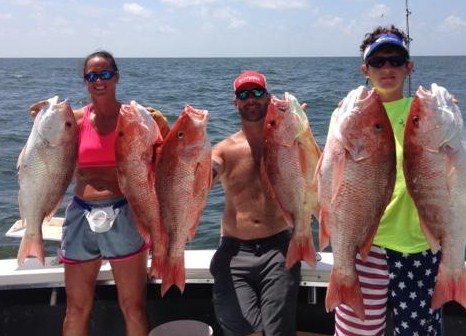 Three anglers holding red snapper caught offshore during red snapper season near Biloxi