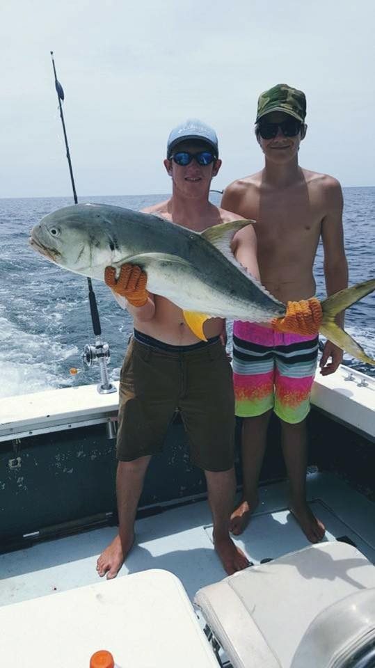 Two young anglers holding a jack crevalle caught on a Mississippi Gulf Coast trolling charter