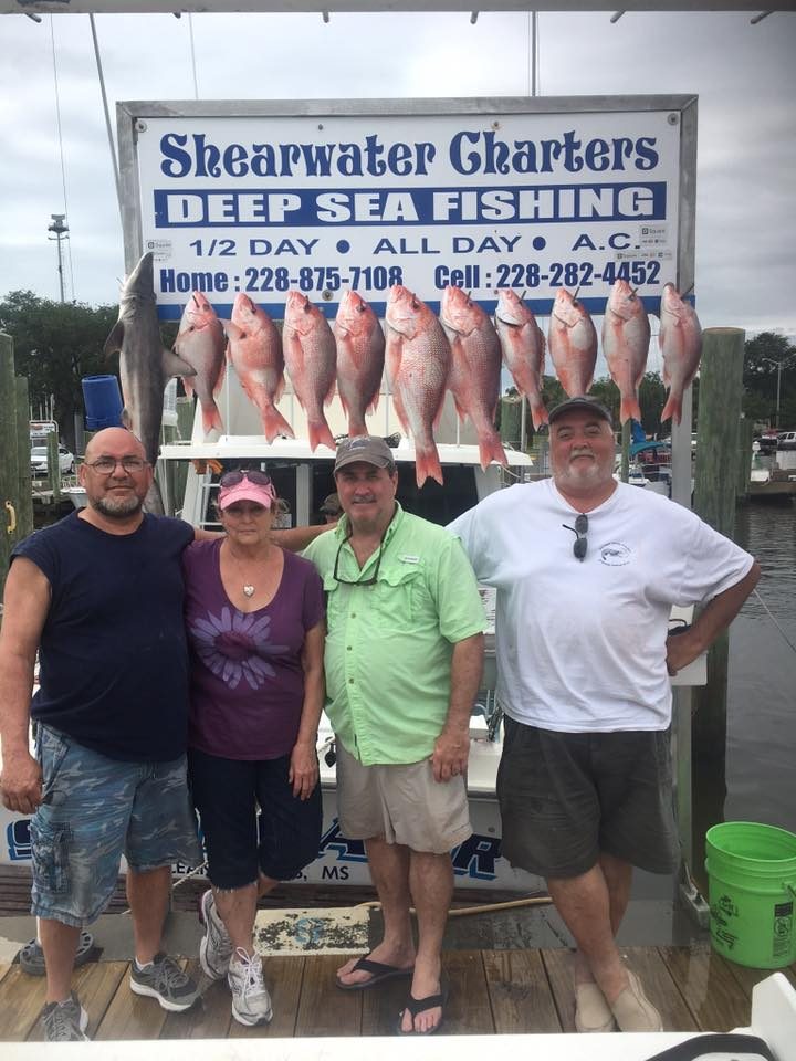 Group with a full limit of red snapper hanging at the Shearwater Charters sign in Biloxi