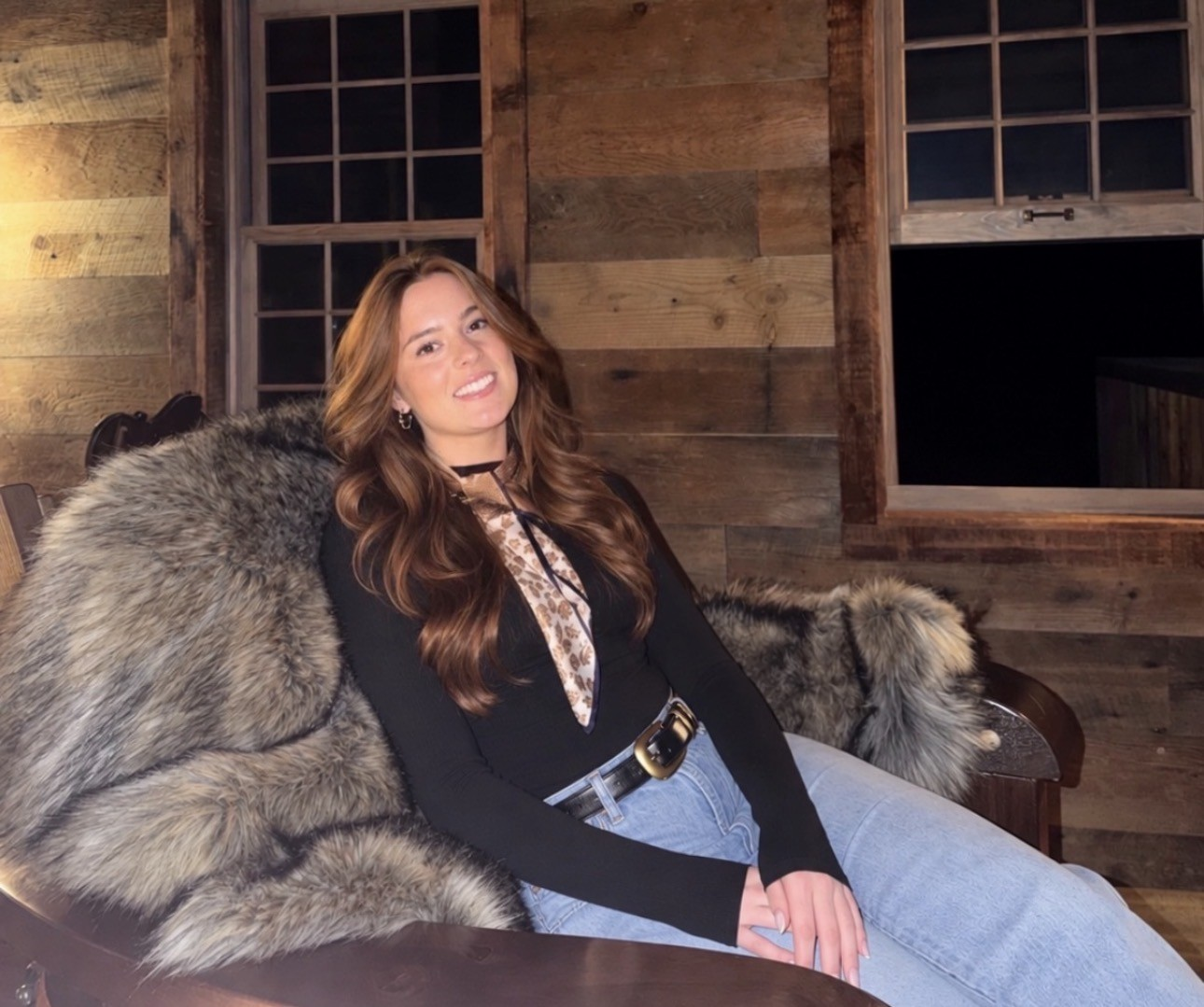 Christina smiling in a warm rustic setting