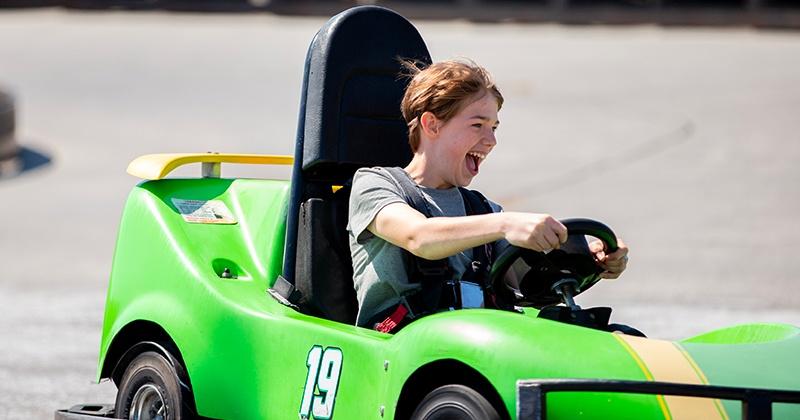 teen driving green go kart on Young Champions track