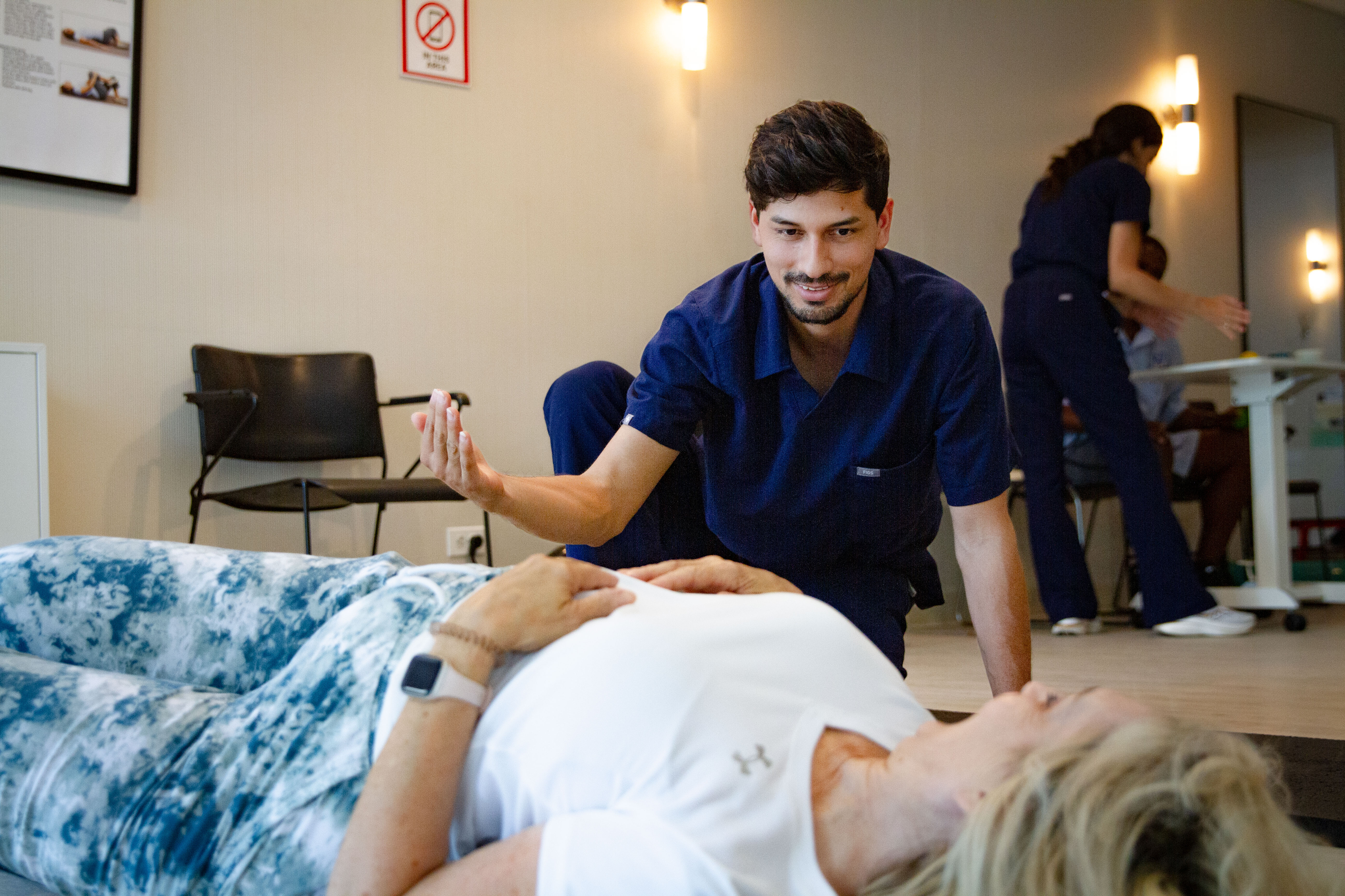 Physical therapist guiding an injured federal worker through core rehabilitation and pain-free movement