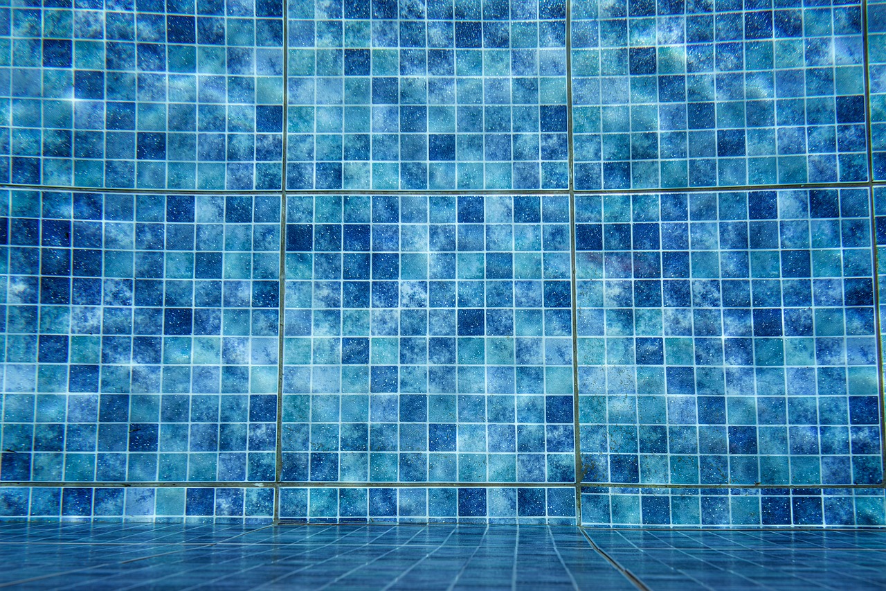 Crystal clear saltwater swimming pool with vibrant blue mosaic waterline tile