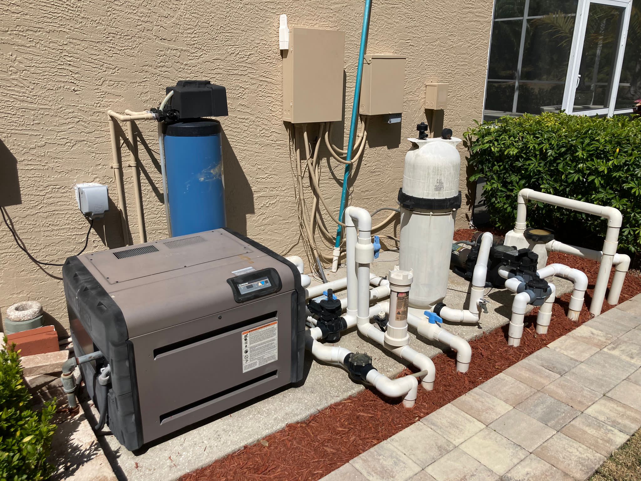 Complete residential swimming pool equipment pad including heater, filter, pump, chlorinator and manifold plumbing