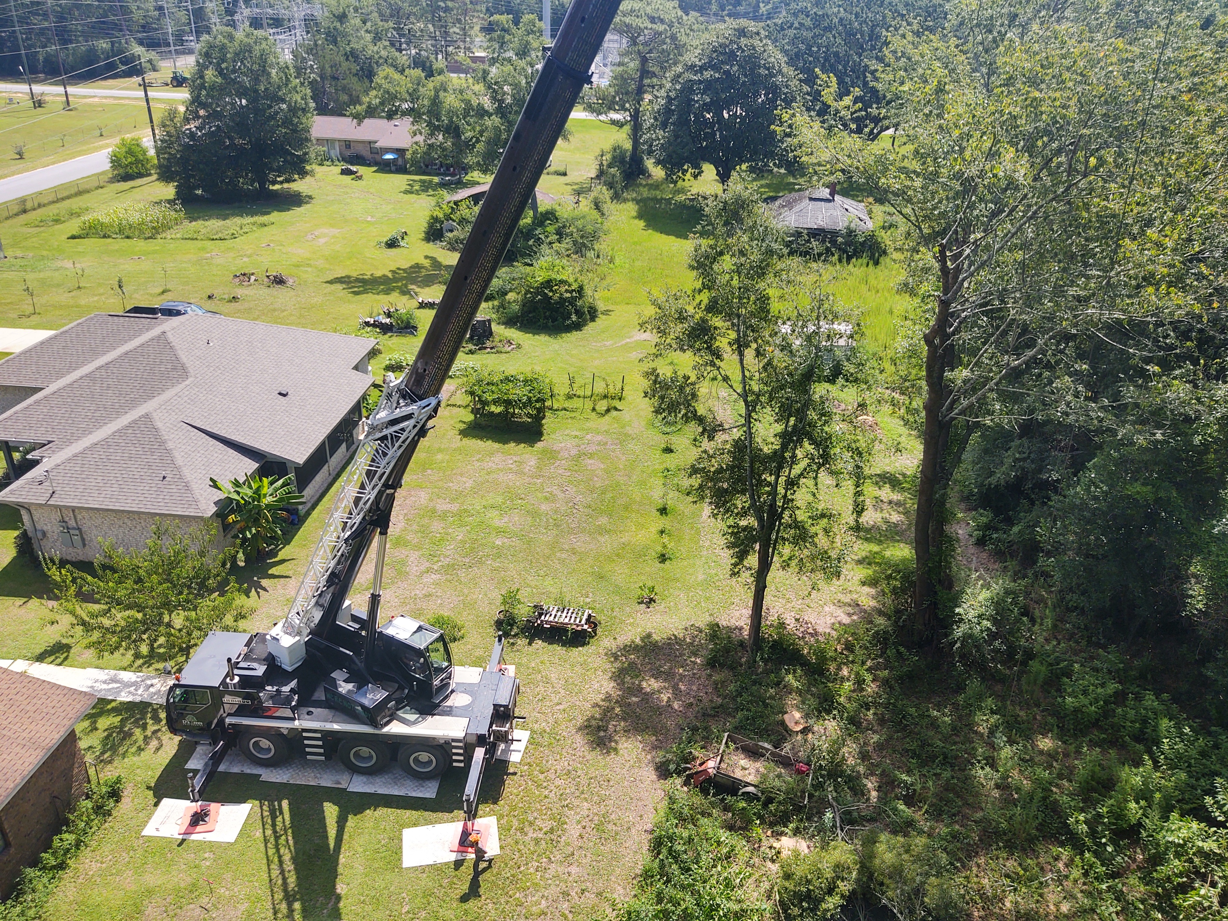 Aerial view of D's Trees heavy-duty crane deployed for residential tree service in Pace, Florida