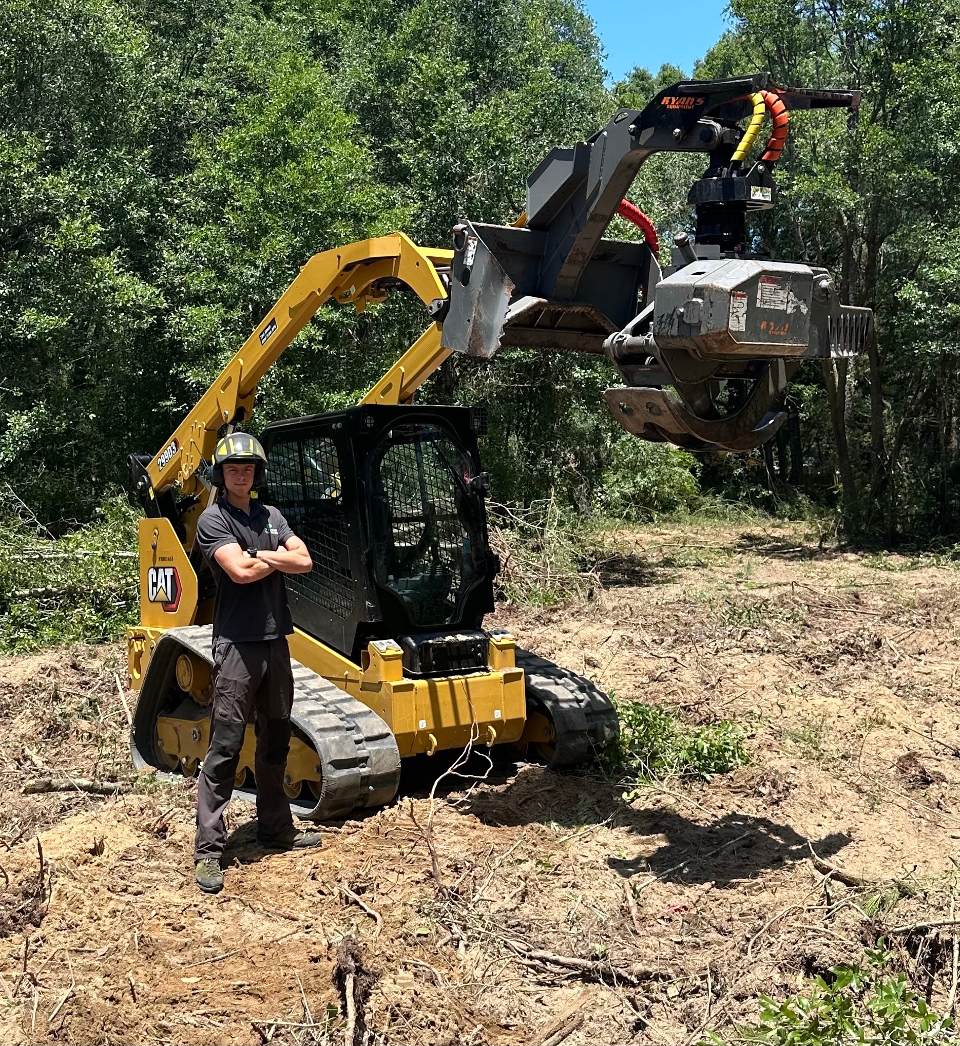 D's Trees heavy-duty CAT track loader with grapple attachment on a tree removal job