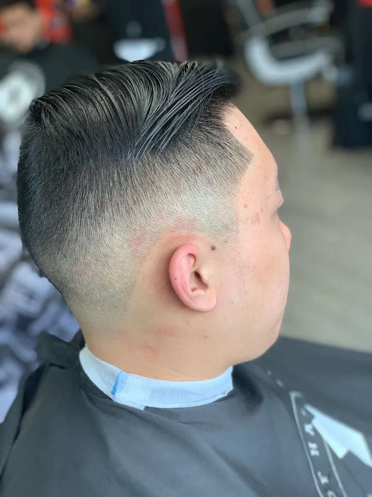 Clean comb-over low skin fade and temple taper — House of Haze