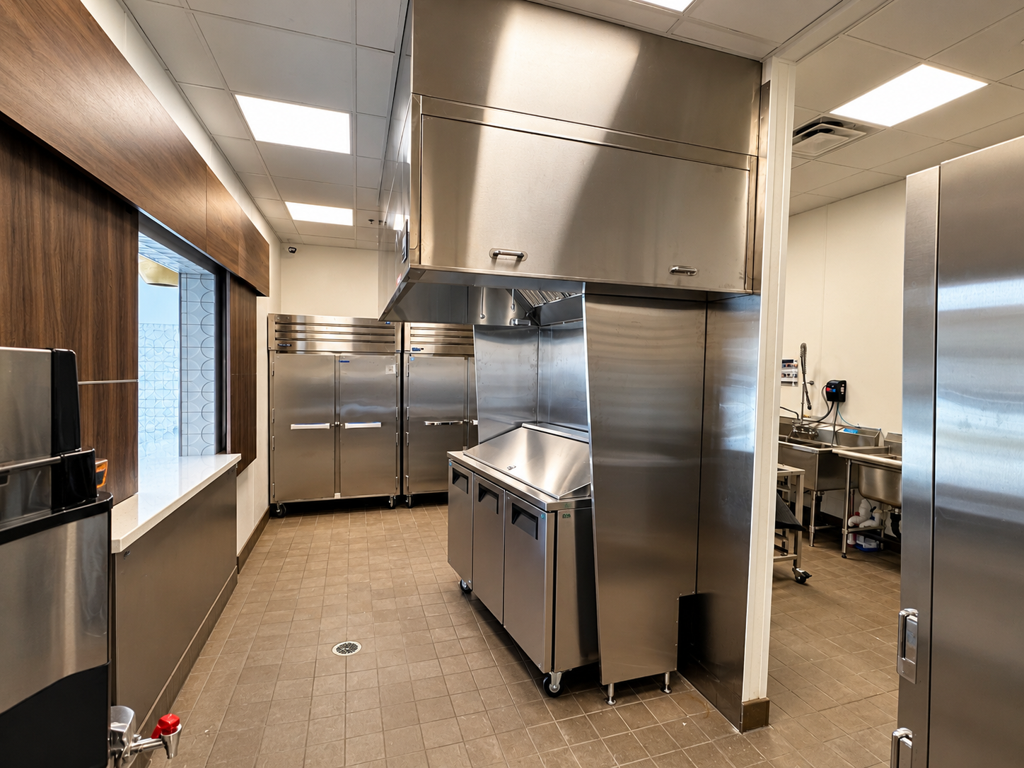 Commercial food service line with stainless steel exhaust hood, warming stations, and commercial refrigeration at Abbey Inn