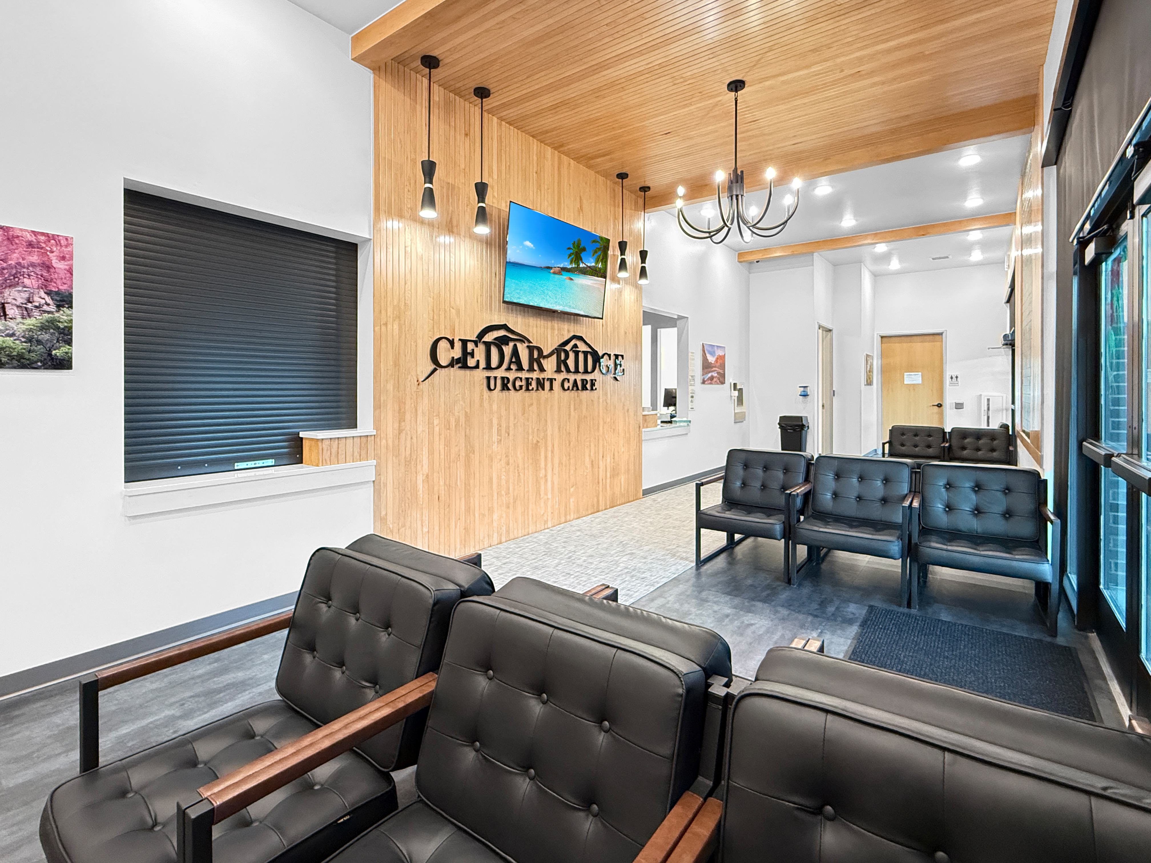 Cedar Ridge Urgent Care lobby and reception area with vertical wood slat wall, dimensional signage, pendant lighting, and patient seating