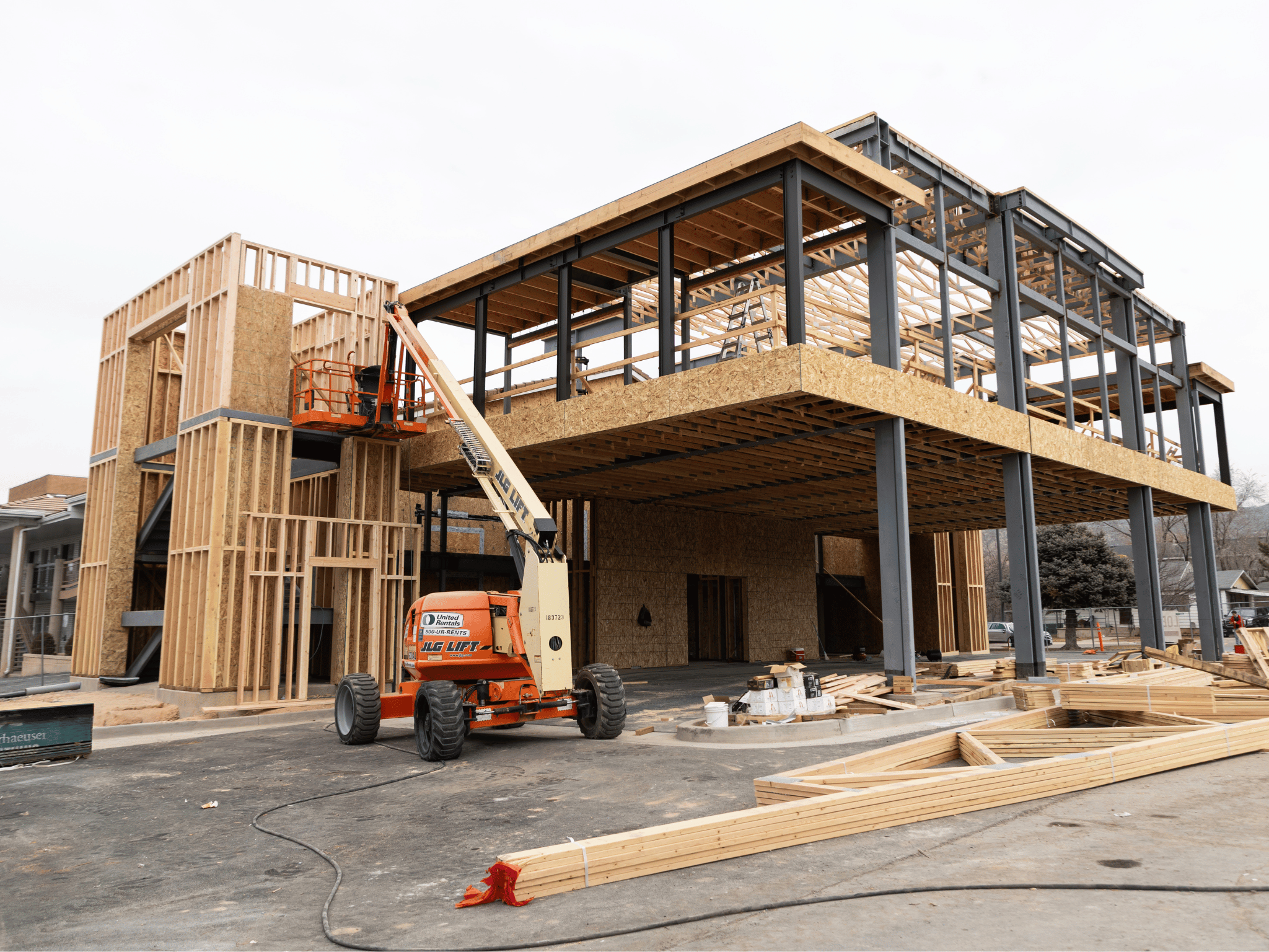 Structural steel and wood framing addition with JLG boom lift equipment on site during Abbey Inn construction