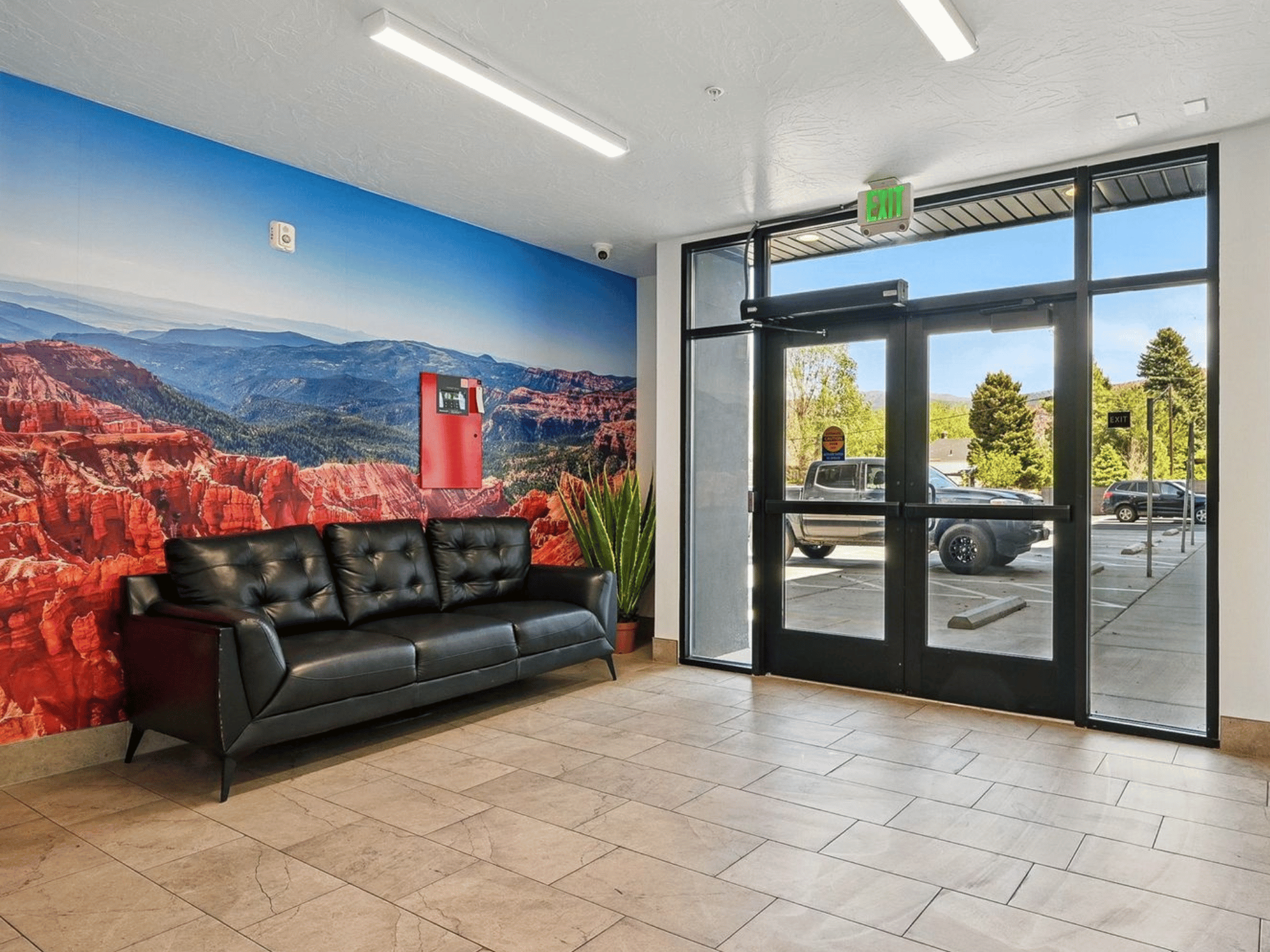 Harding Avenue Lofts resident lobby with seating, red rock canyon wall mural, and glass entry doors