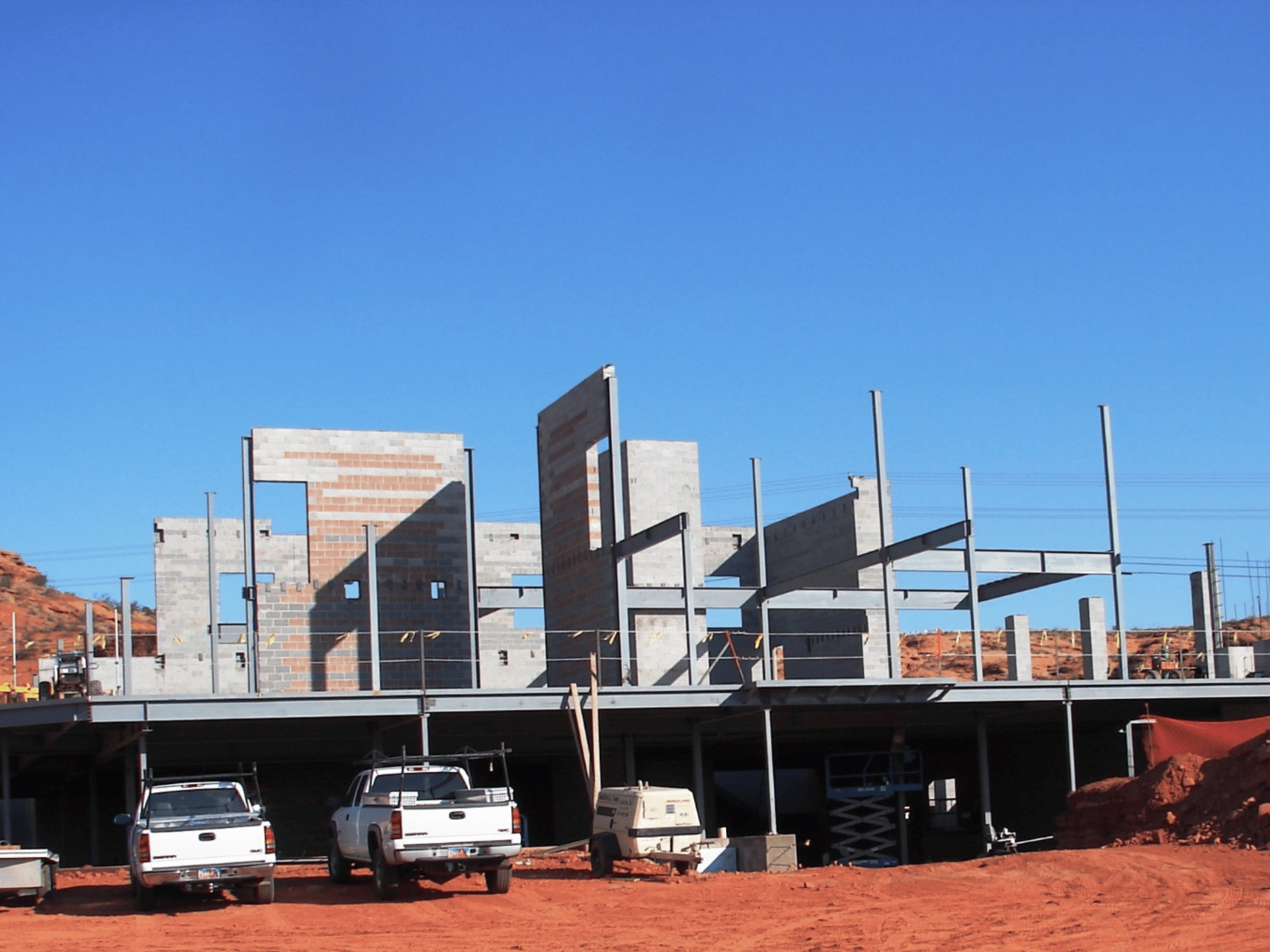 Structural steel framing, masonry shear walls, and foundation podium during early construction