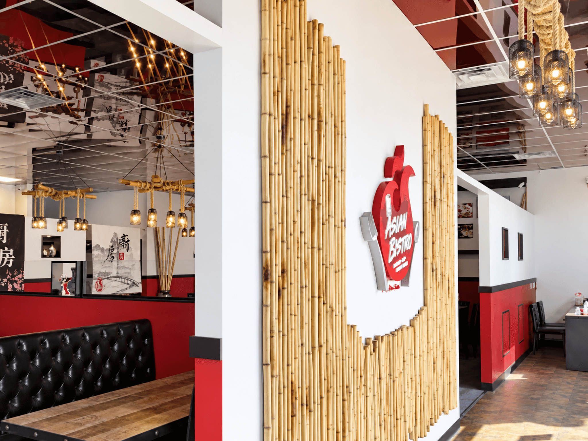 Interior entry feature wall with natural bamboo accents, 3D Asian Bistro logo, and modern dining booth seating