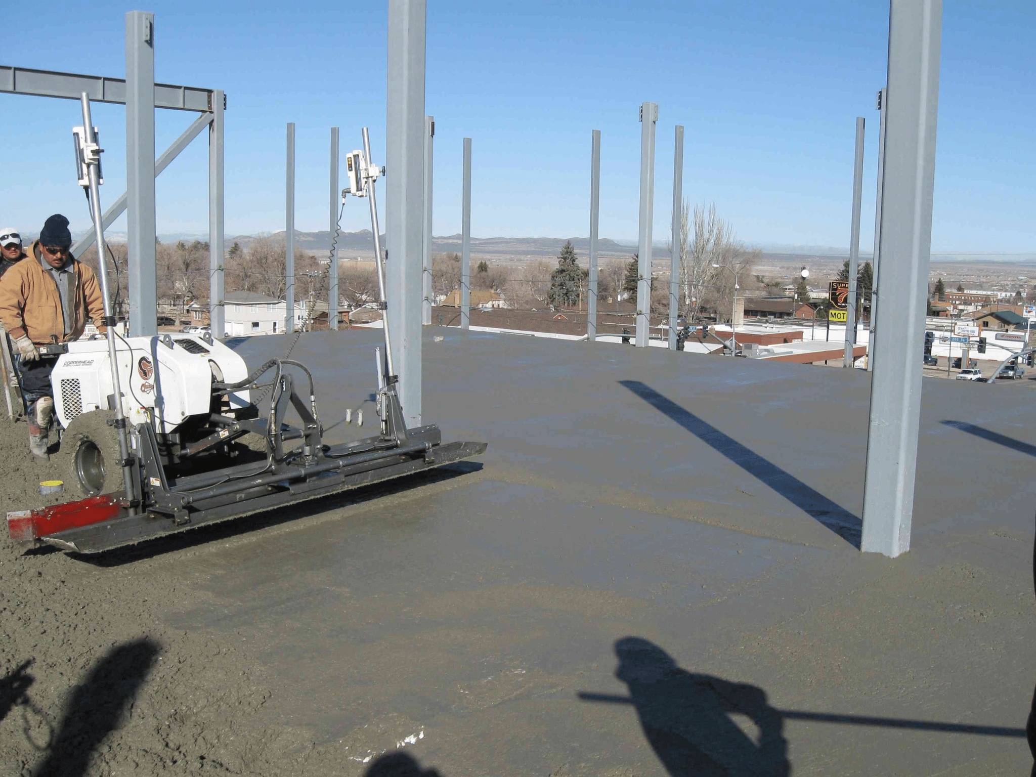 Laser screed finishing concrete elevated deck on structural steel frame during construction