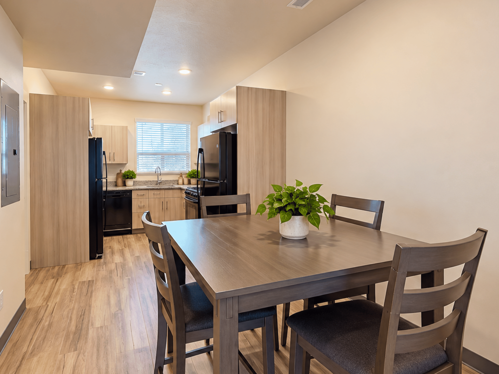 Spacious open dining and kitchen floor plan with dining table, modern cabinetry, dual refrigerators, and recessed ceiling lighting