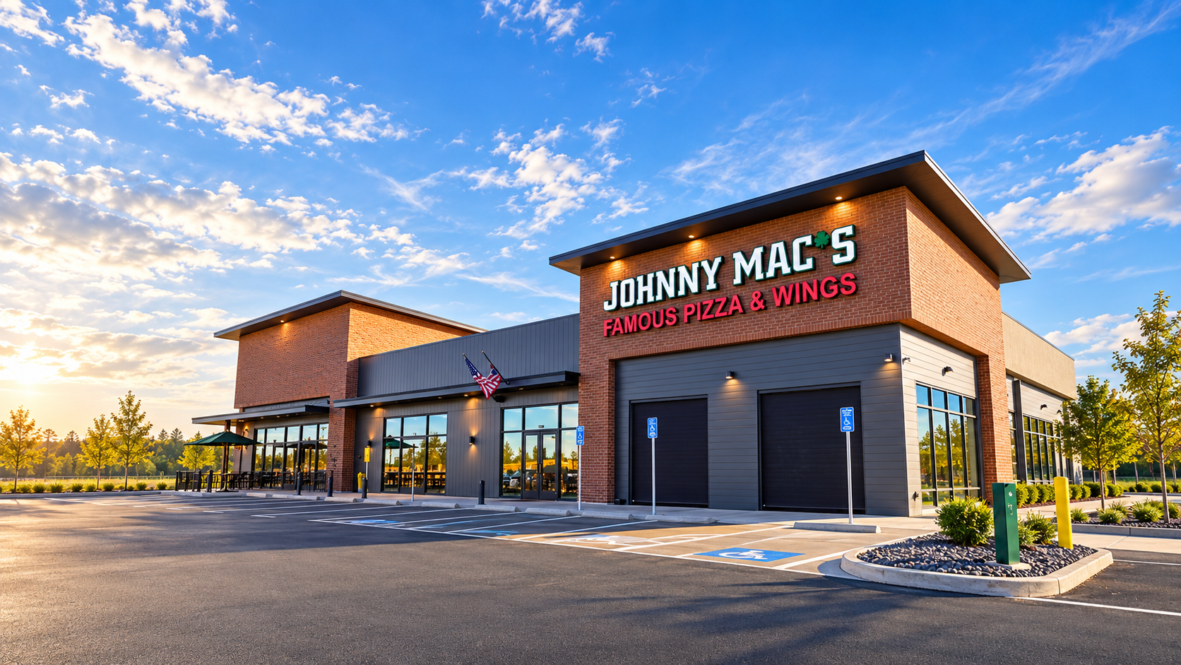 Exterior view of Johnny Mac's Famous Pizza & Wings building at golden hour with outdoor patio and parking
