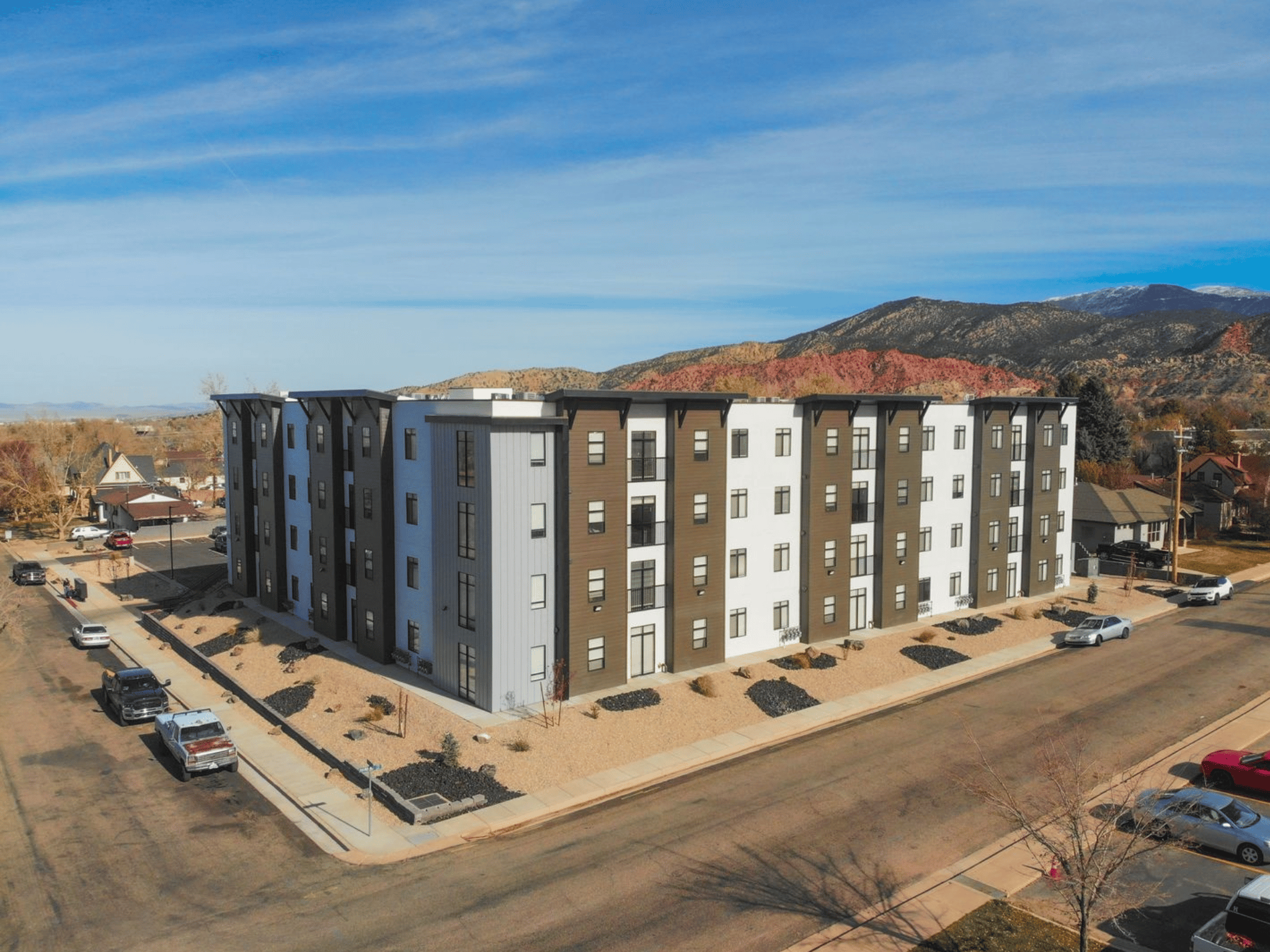 Corner aerial elevation of Harding Avenue Lofts showcasing modern multi-panel facade and surrounding desert landscape