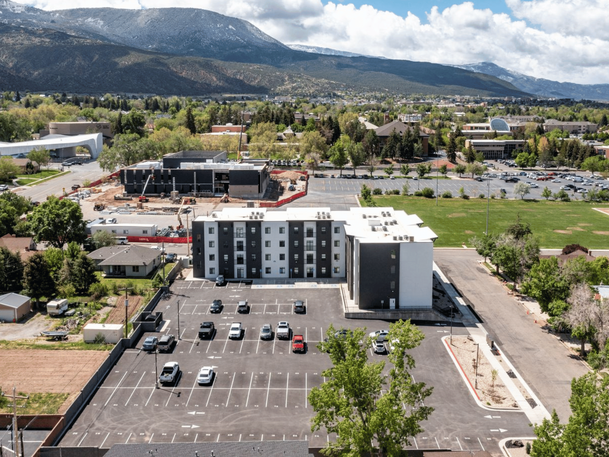 Aerial view of Harding Avenue Lofts student housing building and parking lot with Southern Utah mountains in the background