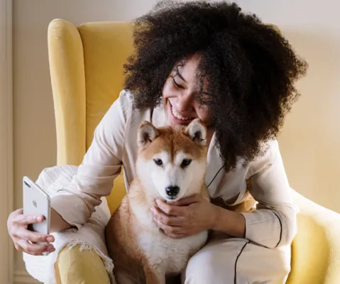 Woman with dog using phone safely in healthy indoor environment