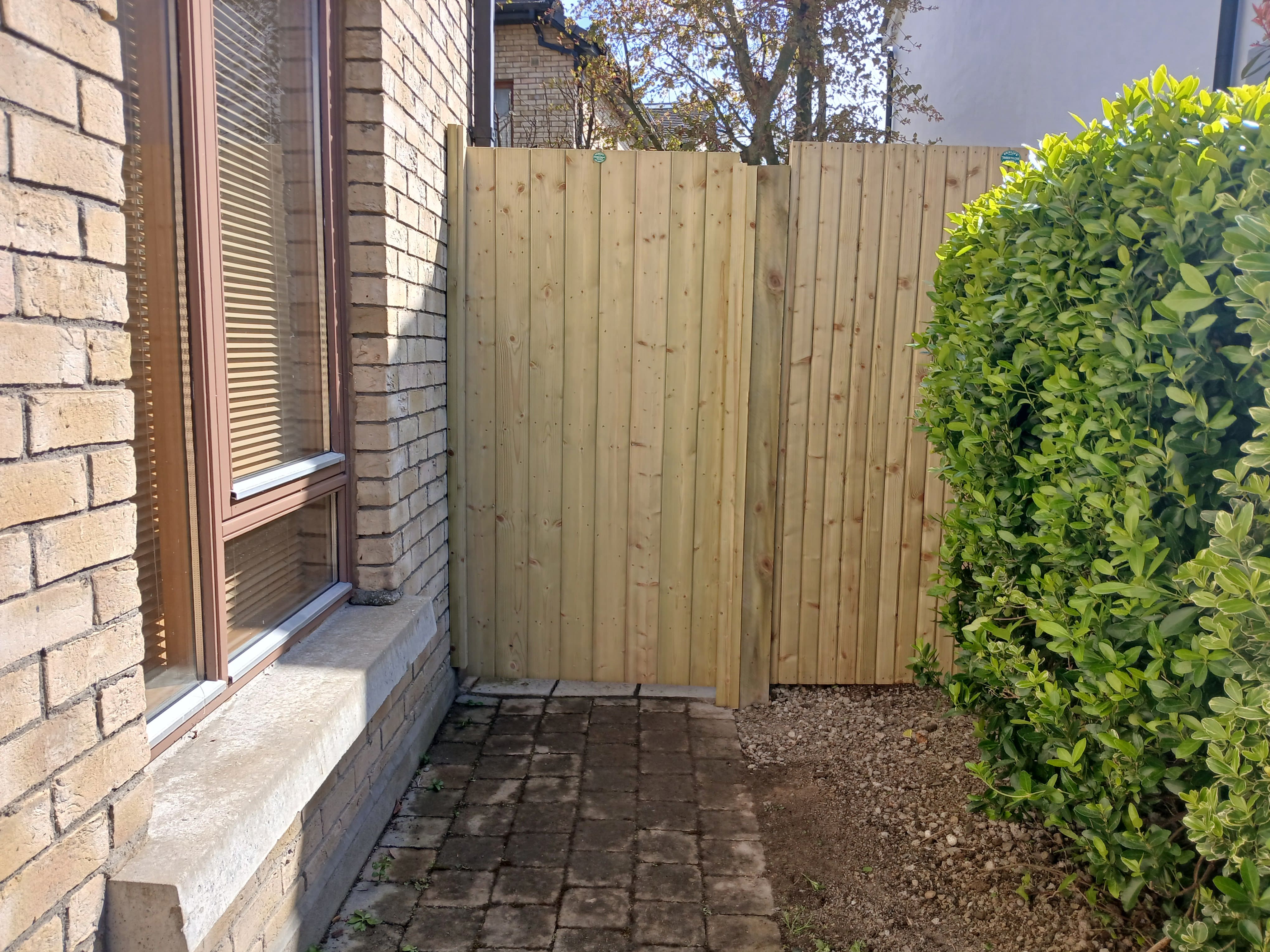 Custom timber side boundary fence and matching timber access gate installed alongside brickwork by Daniel O'Byrne in a Dublin South Side garden.