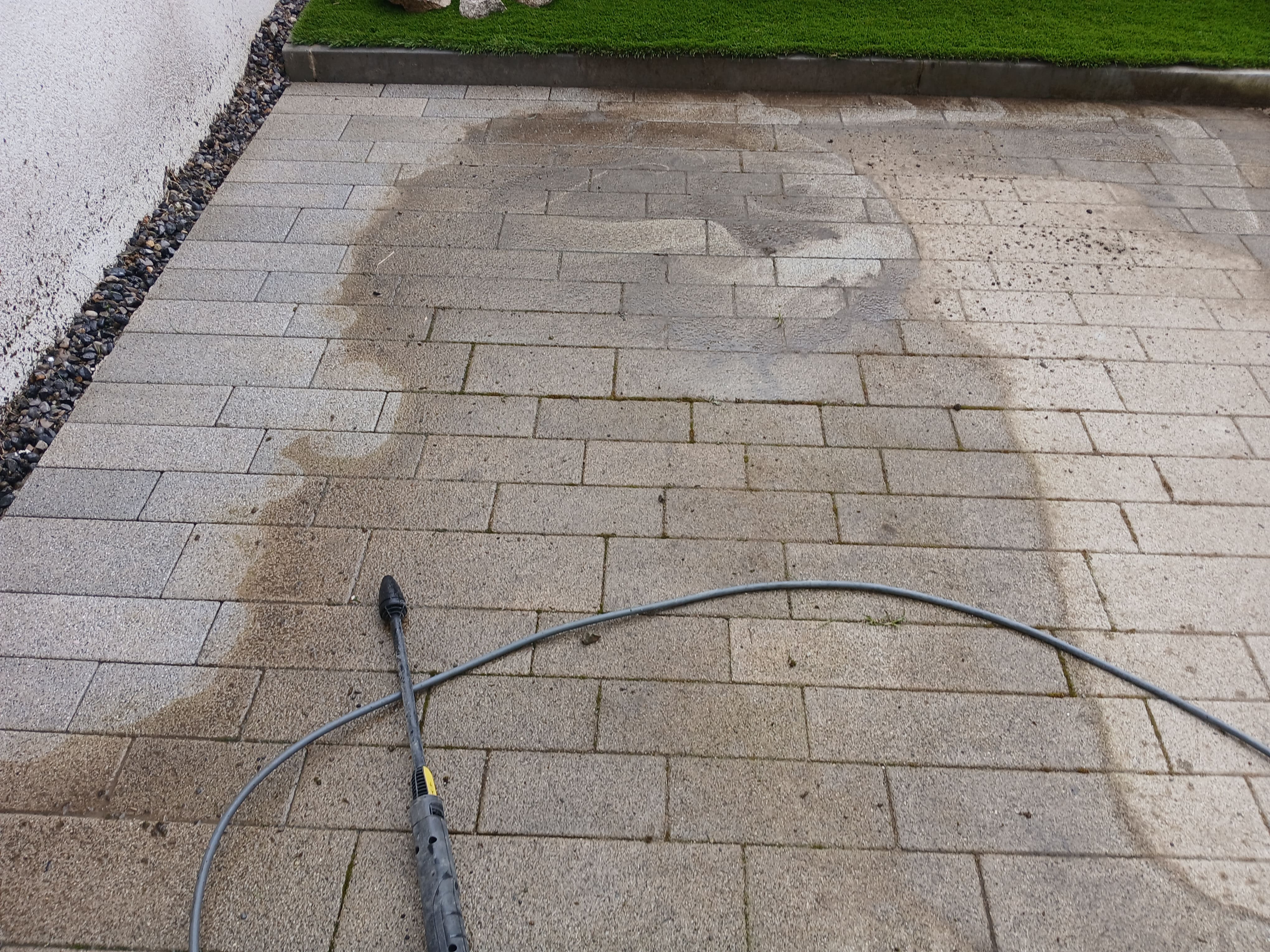 During power washing showing the lance and rotary clean mark on weathered paving in a South Dublin garden.