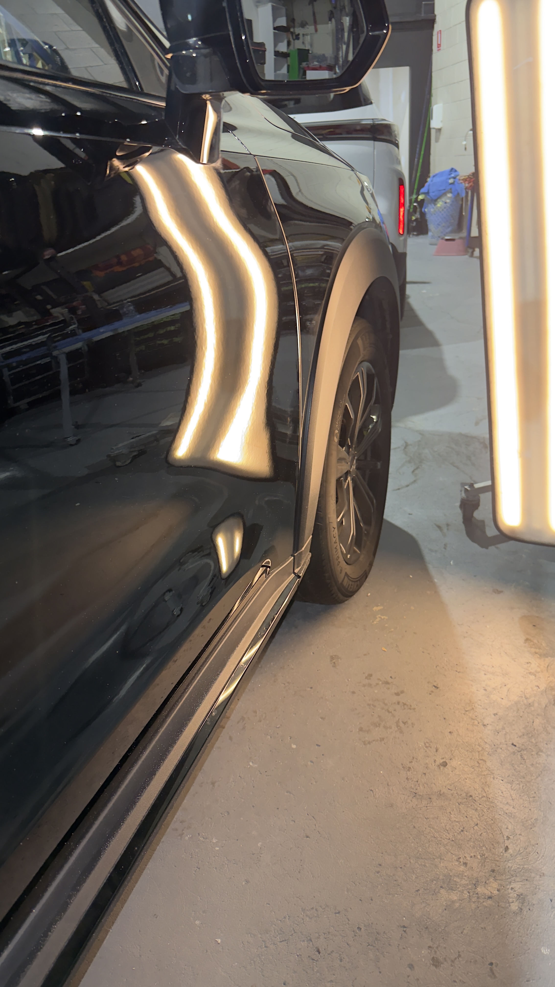 Precision PDR dent reflection board on black vehicle door panel