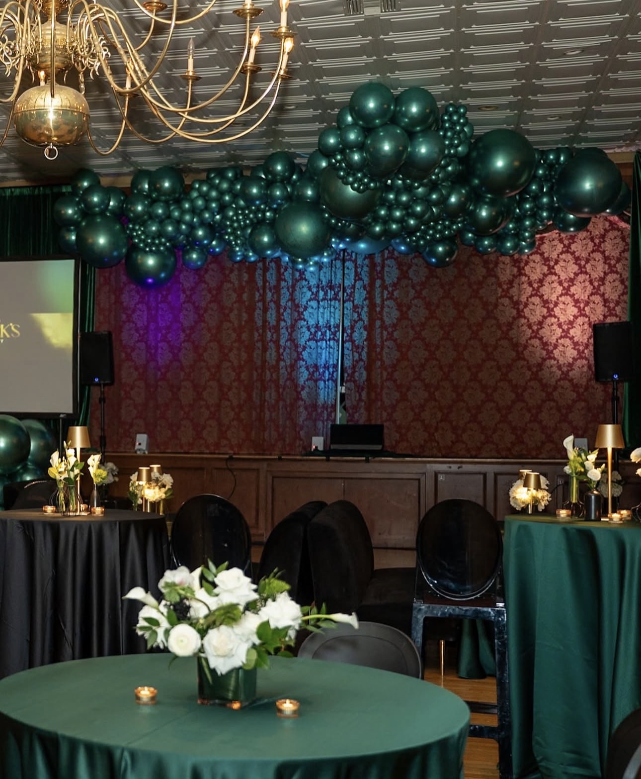 Emerald and gold luxury gala reception ballroom styling with custom overhead balloon cloud