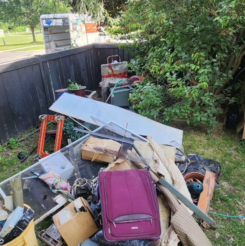 Backyard with a pile of junk before cleanup