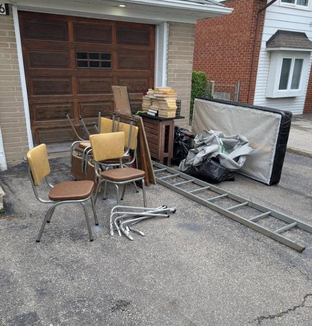 Driveway with chairs, a mattress and a ladder before cleanup