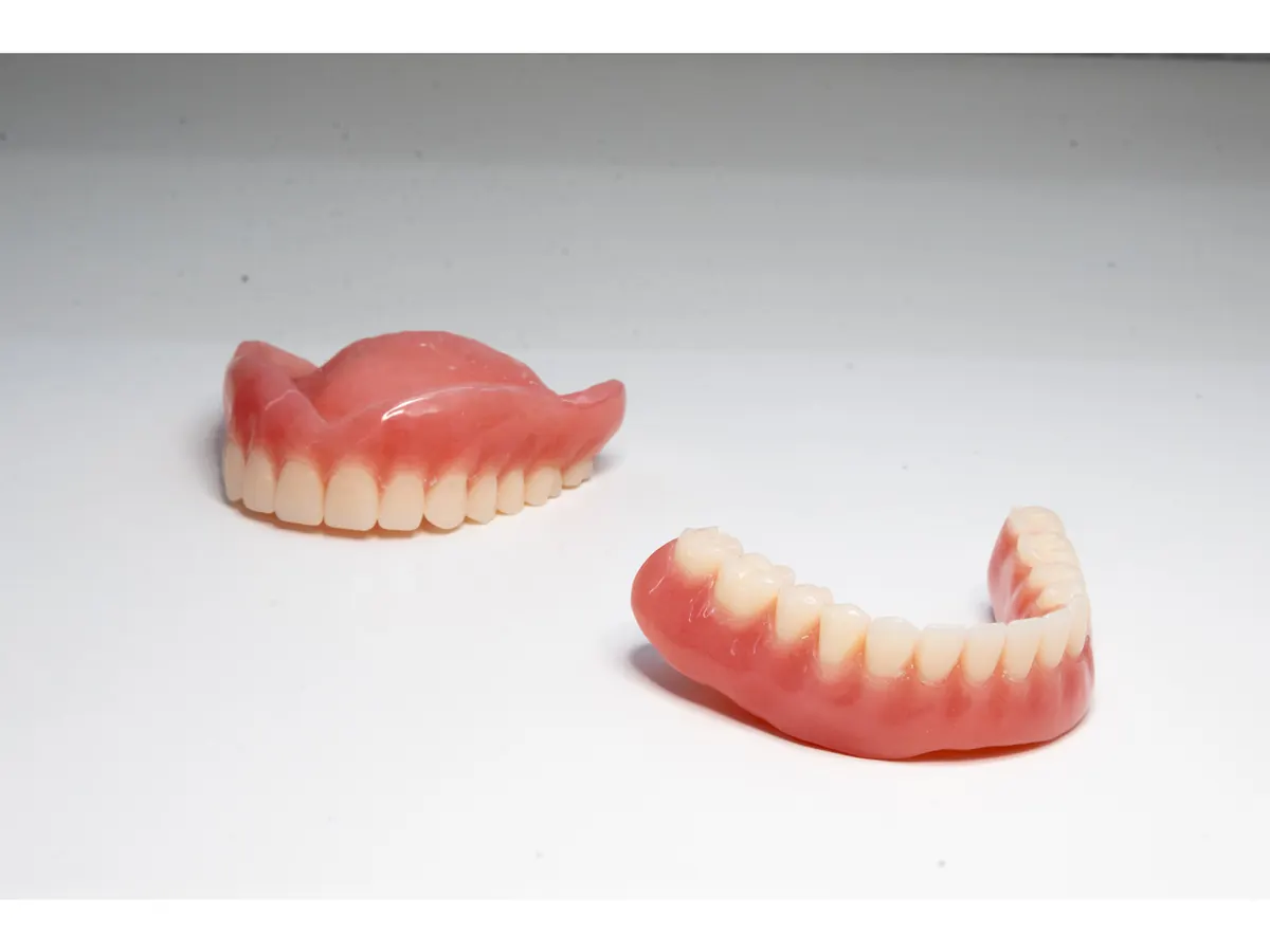 Complete upper and lower denture set on a white background