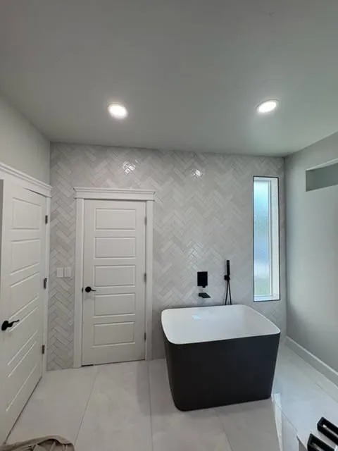Full-Wall Herringbone Tile & Freestanding Modern Soaking Tub