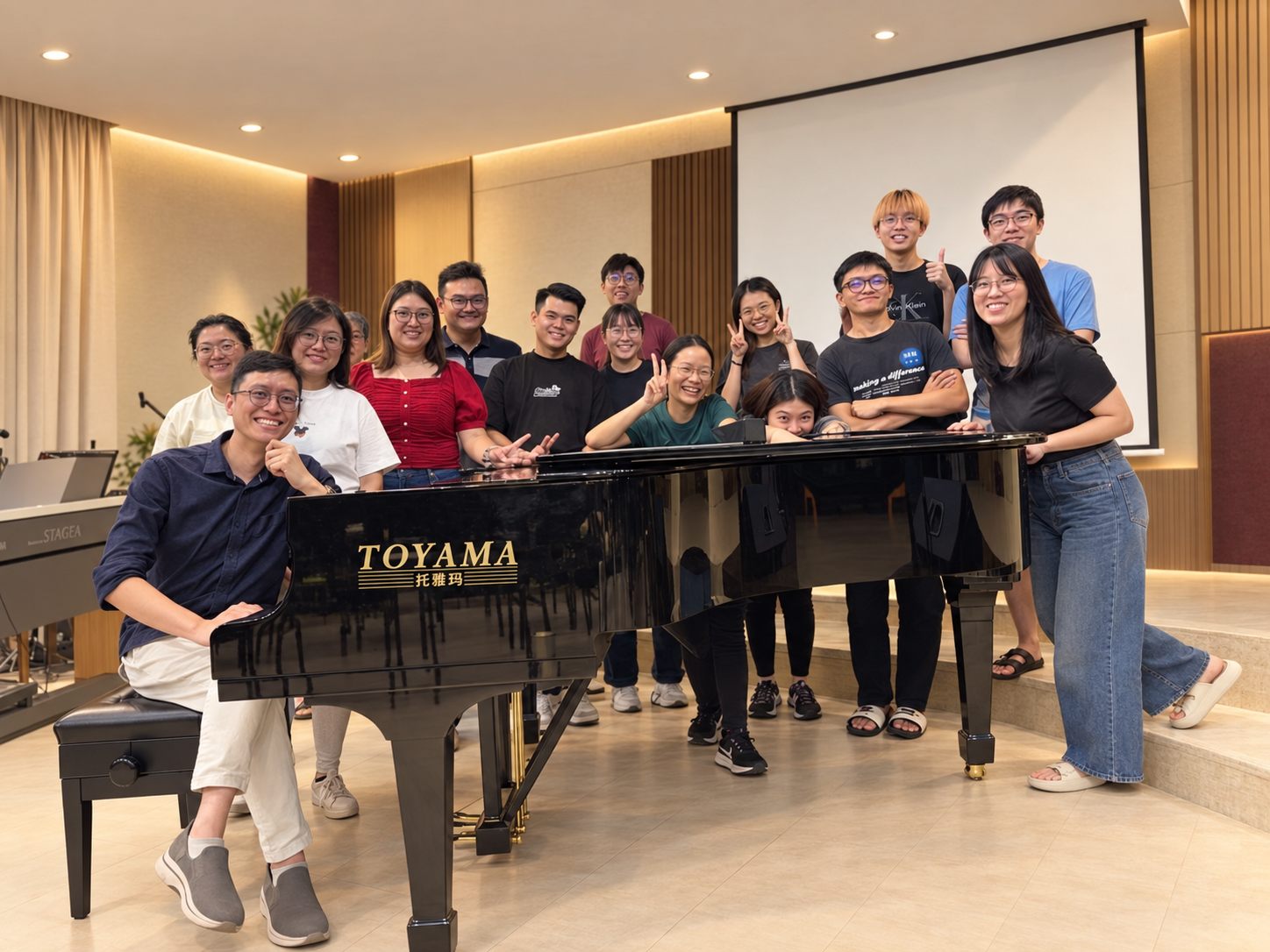 Sam Leong with piano students around a grand piano