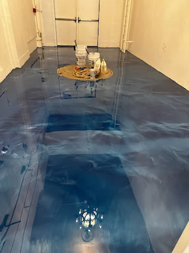 Hudson Epoxy Flooring completed high-gloss blue-gray metallic interior floor reflecting double doors and chandelier light