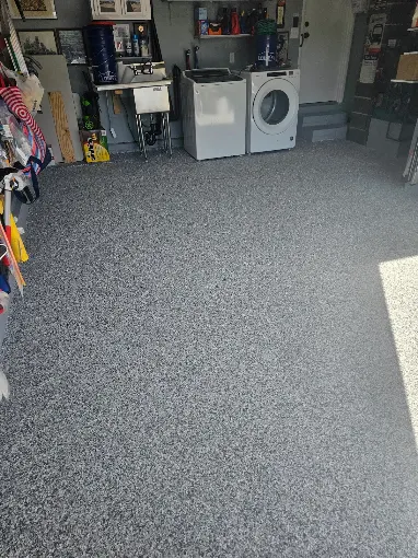 Hudson Epoxy Flooring completed gray decorative flake coating in residential garage and laundry area with washer, dryer, and utility sink