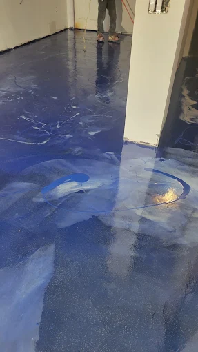 Hudson Epoxy Flooring completed deep oceanic blue metallic high-gloss floor with white swirl depth and high-reflectivity around column and doorway
