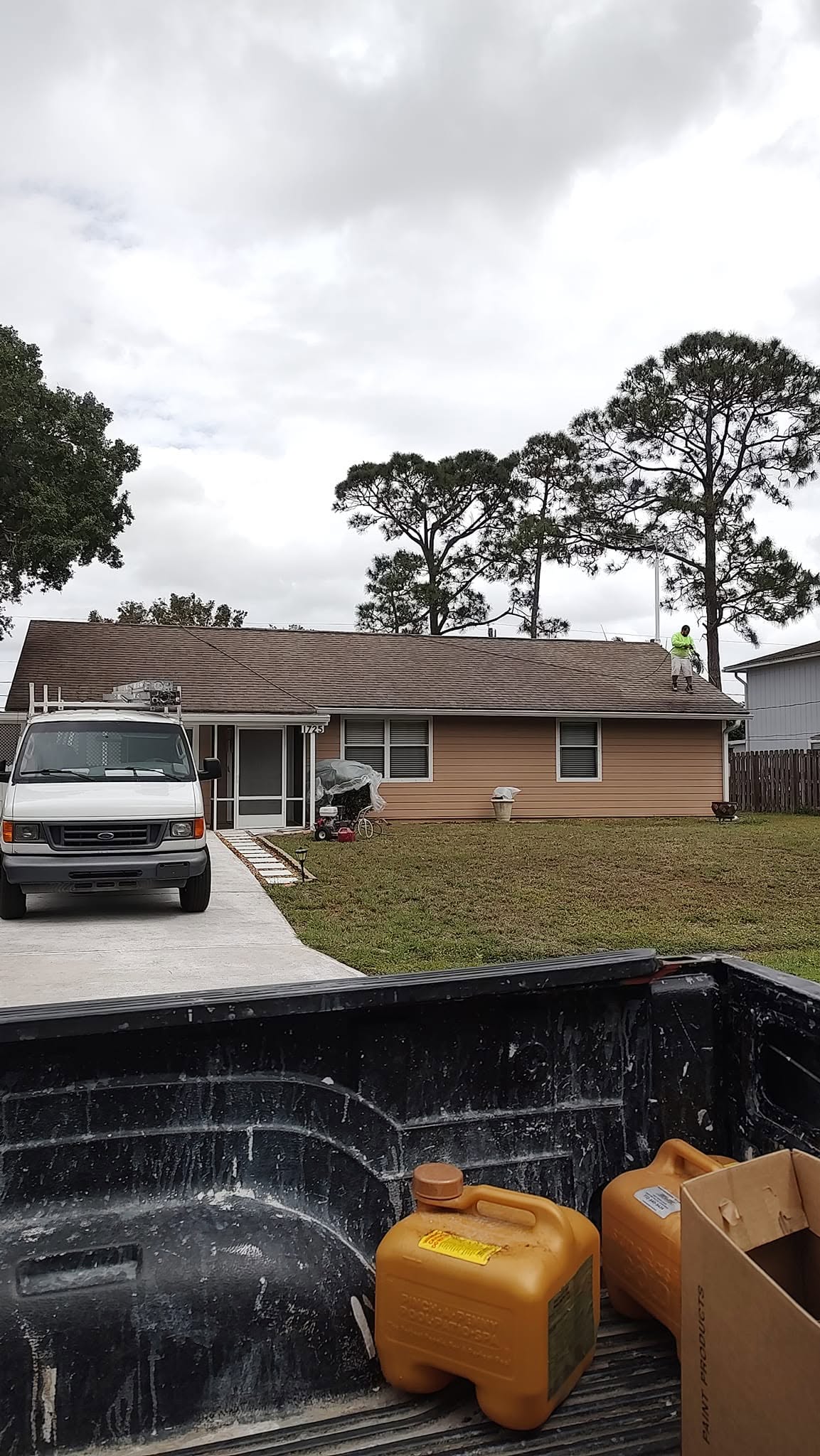 Work truck and crew staging prep and roof wash on a single-story home exterior in Naples